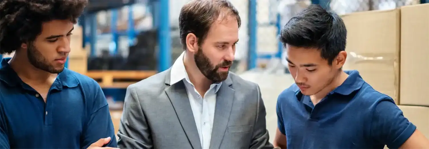 Directeur Qualité de transition encadrant une équipe en usine pour garantir le respect des normes et processus de production.