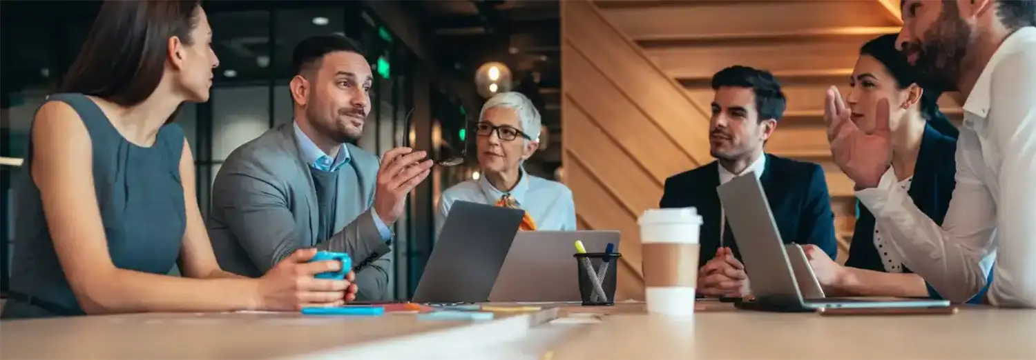 DRH de transition en réunion avec le comité de direction, pilotant la stratégie RH, le dialogue social et la transformation organisationnelle.