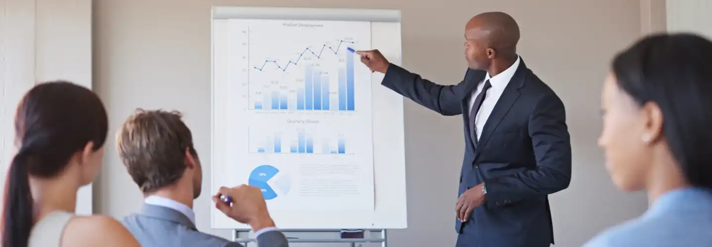 Contrôleur de gestion de transition présentant des indicateurs financiers et des graphiques de performance à une équipe en réunion.